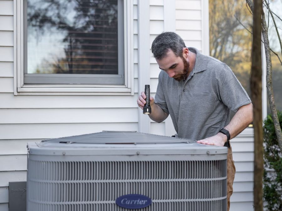 Oz technician checking an outdoor HVAC unit